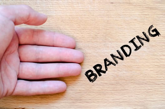 Human hand over wooden background and branding text concept
