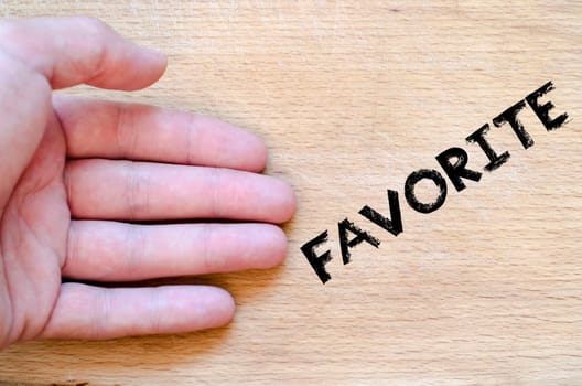Human hand over wooden background and favorite text concept