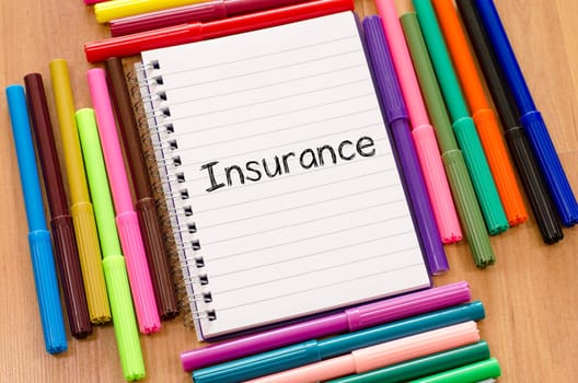 Insurance text concept over notepad background