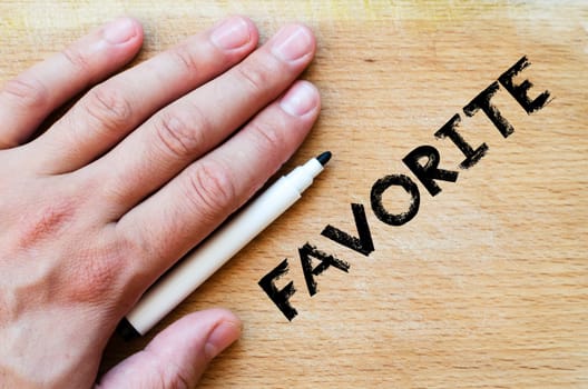 Human hand over wooden background and favorite text concept