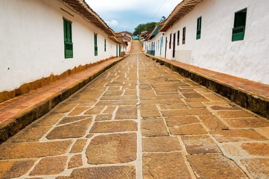 View of a beautiful street lined with historic colonial buildings in Barichara, Colombia