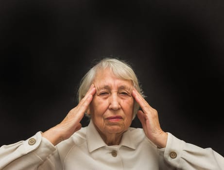 Senior Woman With Head In Hands Looking Weary on black