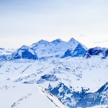 Winter snow covered mountain peaks in Europe. The Alps winter mountain landscape