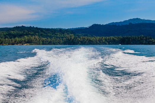Water stream after speed boat.  Trail on water surface behind of fast moving motor boat. Waves on blue sea