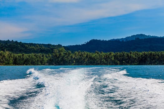 Water stream after speed boat.  Trail on water surface behind of fast moving motor boat. Waves on blue sea