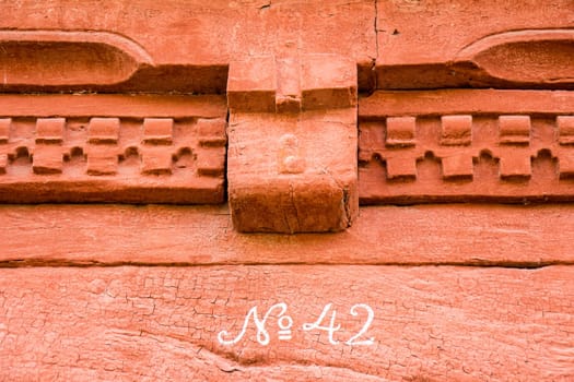 Number 42 on red painted brick wall