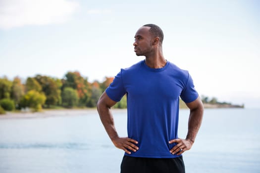 young black man wearing athletic wear on the beach