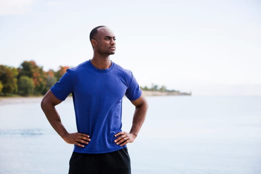 young black man wearing athletic wear on the beach