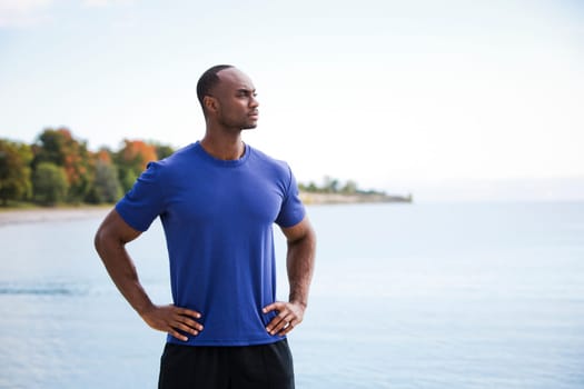 young black man wearing athletic wear on the beach