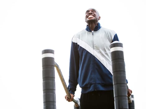 Active black man in training suit exercising at outdoor gym
