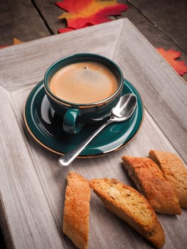 Delicious cup of espresso with cantuccini on a wooden plate