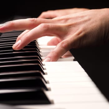 Close up shot of male hands playing piano with selective focus
