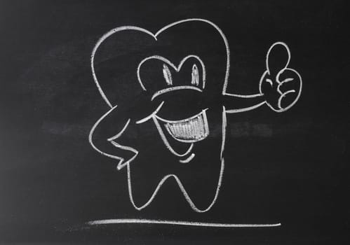 Happy tooth on a chalkboard with thumbs up, health care concept background