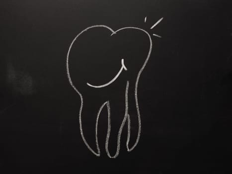 Hand drawn smiling tooth on a chalkboard, health care concept background