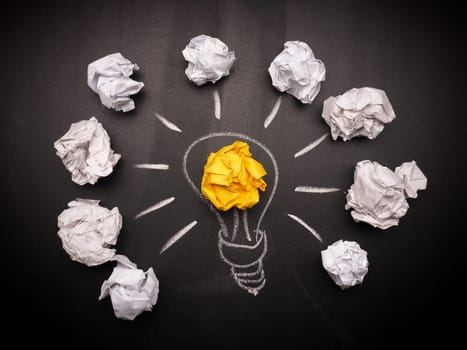 Crumpled paper with a light bulb, new idea concept background