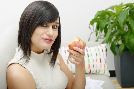 young student girl eating an apple in home