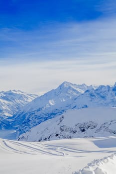 Winter snow covered mountain peaks in Europe. The Alps winter mountain landscape
