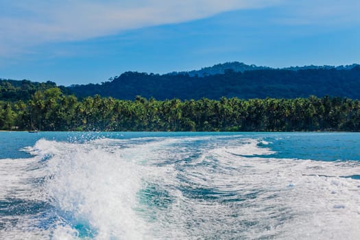 Water stream after speed boat.  Trail on water surface behind of fast moving motor boat. Waves on blue sea