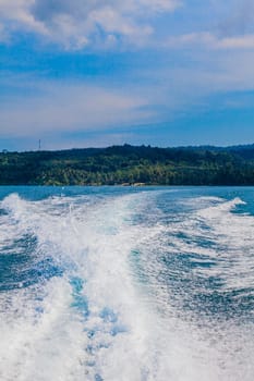 Water stream after speed boat.  Trail on water surface behind of fast moving motor boat. Waves on blue sea