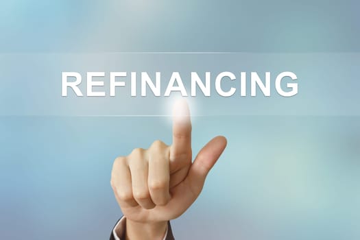business hand pushing refinancing button on blurred background