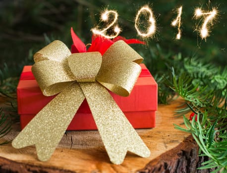 red christmas gift on wood and tree background