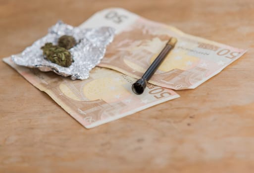 close up of marijuana,pipe and euro money
