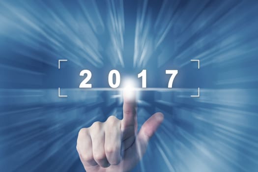 hand clicking on 2017 button with zoom effect background