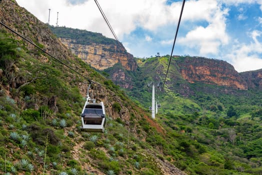 Rugged landscape view of an aerial tram rising up a cliff through Chicamocha Canyon in Santander, Colombia