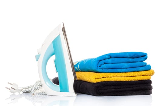 iron and clothes.  Steam iron and colored towels isolated on white background