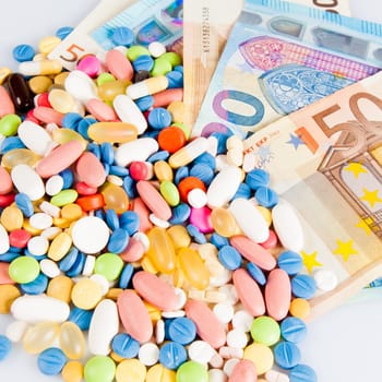Pills of different colors on money