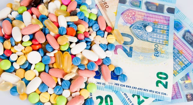 Pills of different colors on money