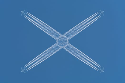 Four planes flying at high altitude. Contrails against a dark blue sky.