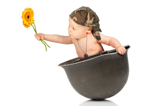 Cute baby girl with flower inside an old military helmet