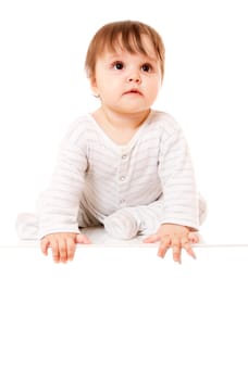 Cute baby sitting on the white floor background with space for text. Isolated.