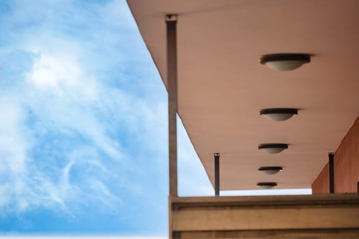 Unique lighting fixtures adorn a contemporary building's overhang.