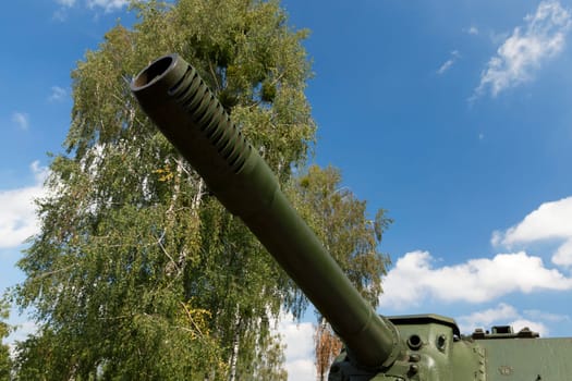the barrel of the old Soviet gun, tank, located in the park. Photo close-up, small depth of field. Summer season
