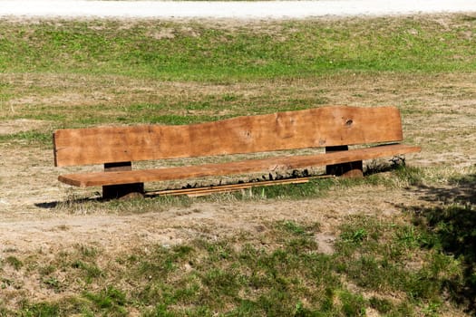 a bench made of wood and painted with orange paint, located in an open space