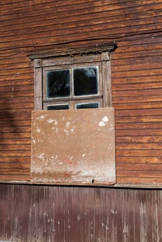 photographed close-up of the old red wooden houses with windows. In the house no one lives