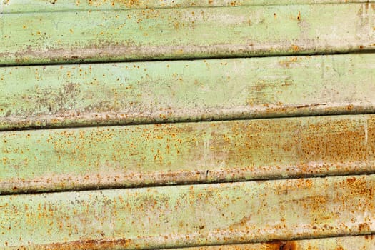 photographed close-up of a metal surface painted in green color, on which there was rust