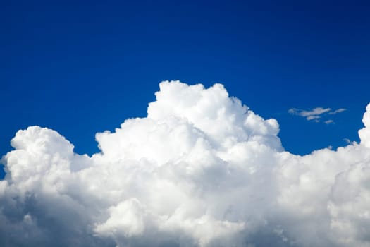 blue sky, which are floating cumulus clouds bright white. Photo taken closeup.