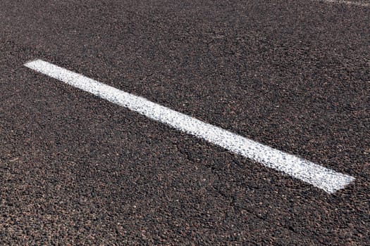 photographed close-up of road marking is located on the roadway, white line on the pavement
