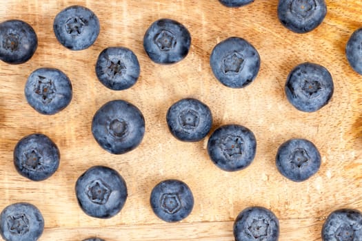photographed closeup harvest ripe blueberries, berries spread out on an old wooden board, from top's photos