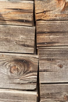 Old wooden surface photographed close-up. Sharpness is not the whole plane, a small depth of field. Wood exposed to weathering and has a number of defects