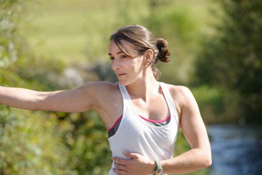 beautiful young fitness woman doing exercise in countryside