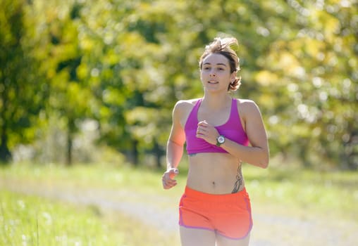 Beautiful  young athletic woman running in countryside