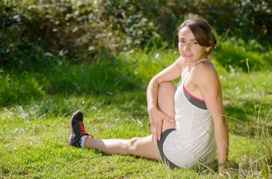 beautiful young fitness woman doing exercise in countryside