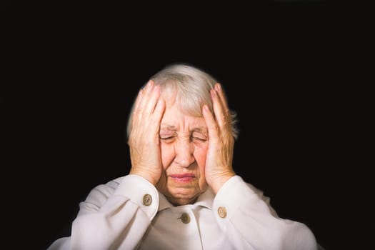 Senior Woman With Head In Hands Looking Weary on black