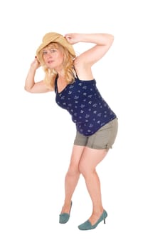 A pretty woman in shorts, holding a straw hat on her head,.isolated for white background..