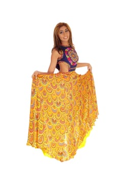 A beautiful young woman standing in a long yellow skirt, lifting it up,.isolated for white background..