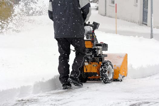 A man clears snow with a snow blower